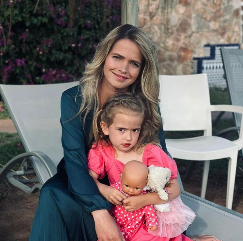 Amira sitting outdoors with a young child